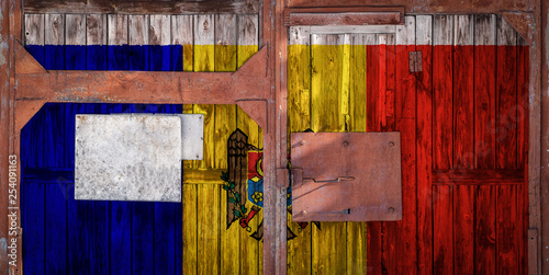 Close-up of old warehouse gate with national flag Moldova. The concept of export-import Moldova, storage of goods and national delivery of goods. Flag in grunge style photo