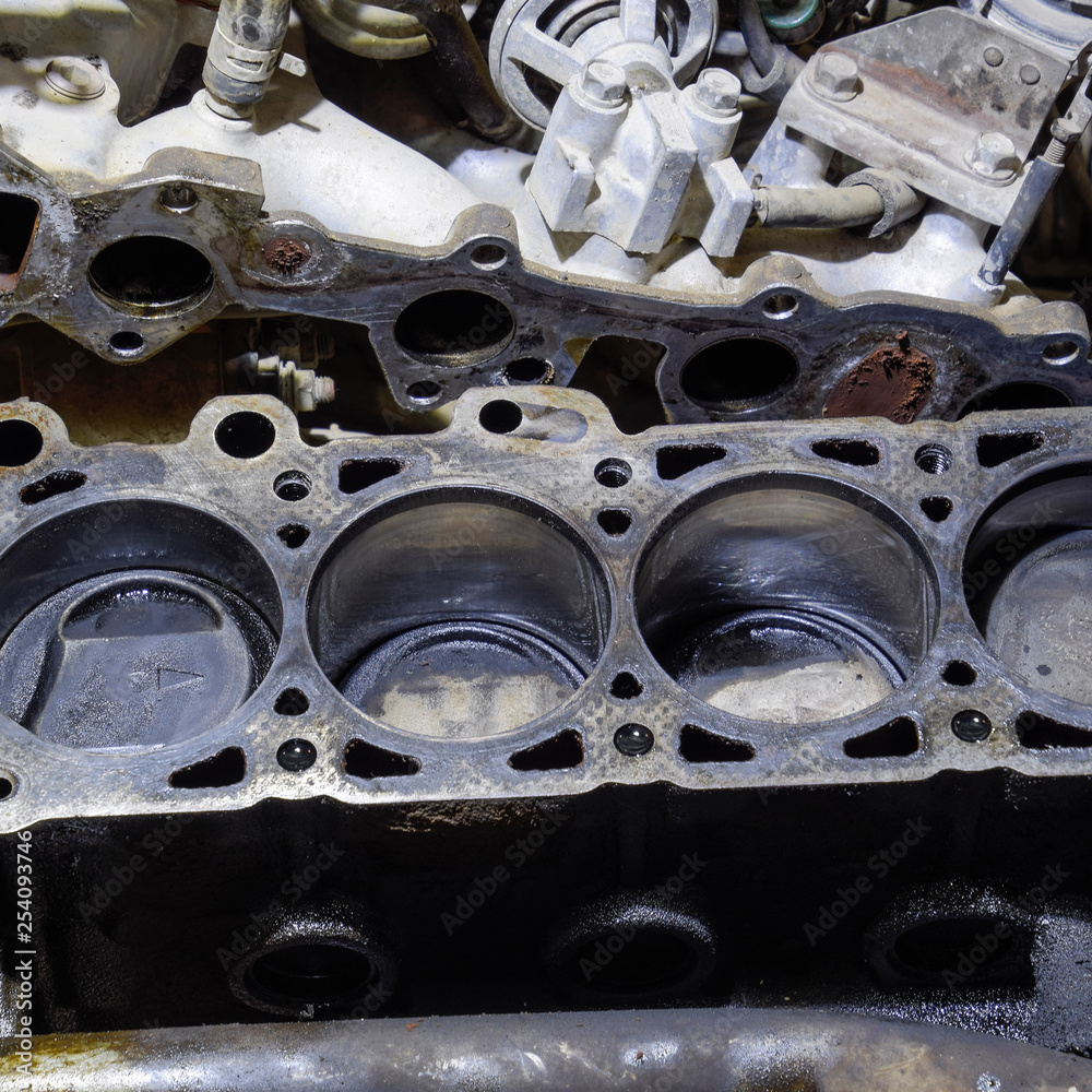 The cylinder block of the four-cylinder engine. Disassembled motor vehicle for repair. Parts in engine oil. Car engine repair in the service The cylinder block of the four-cylinder engine. Disassembled motor vehicle for repair. Parts in engine oil. Car engine repair in the service
