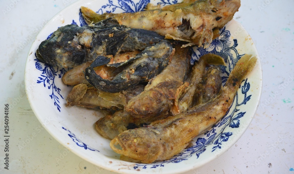 Fried fish gobies on a plate rest on the sea Fried fish gobies on a plate rest on the sea