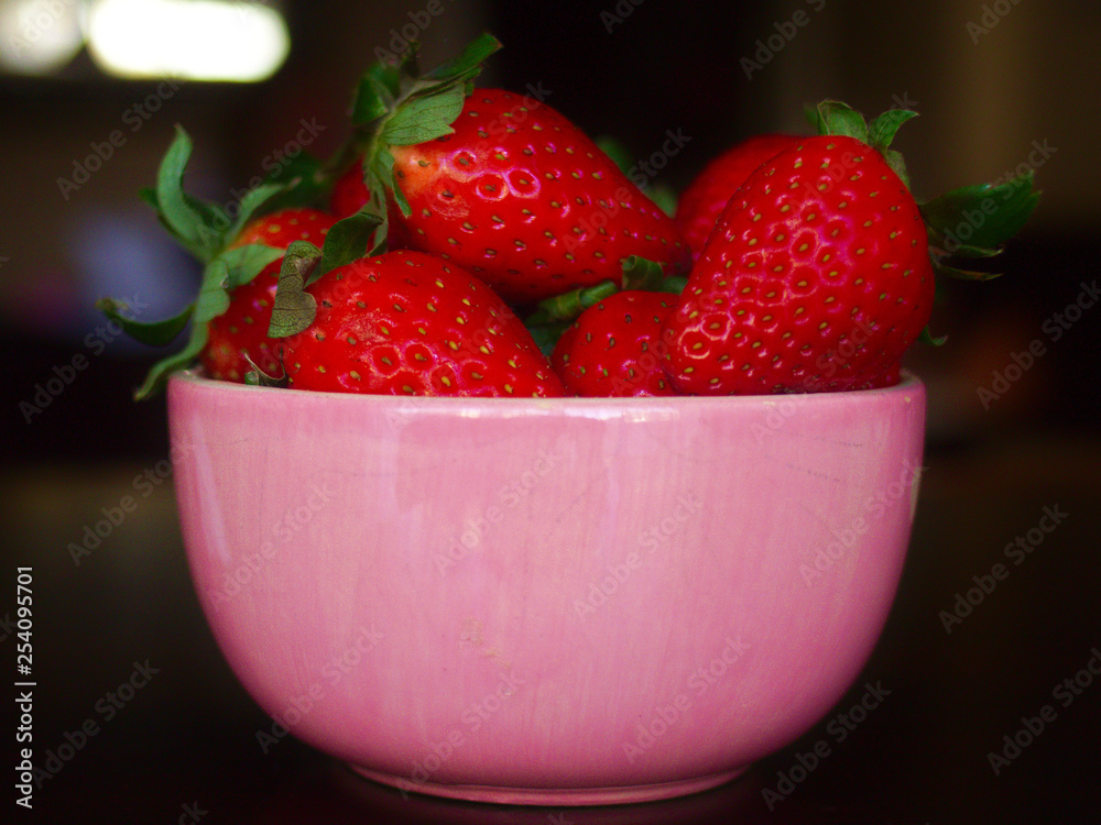 Pink strawberry bowl over dark table. Pink strawberry bowl over dark table.