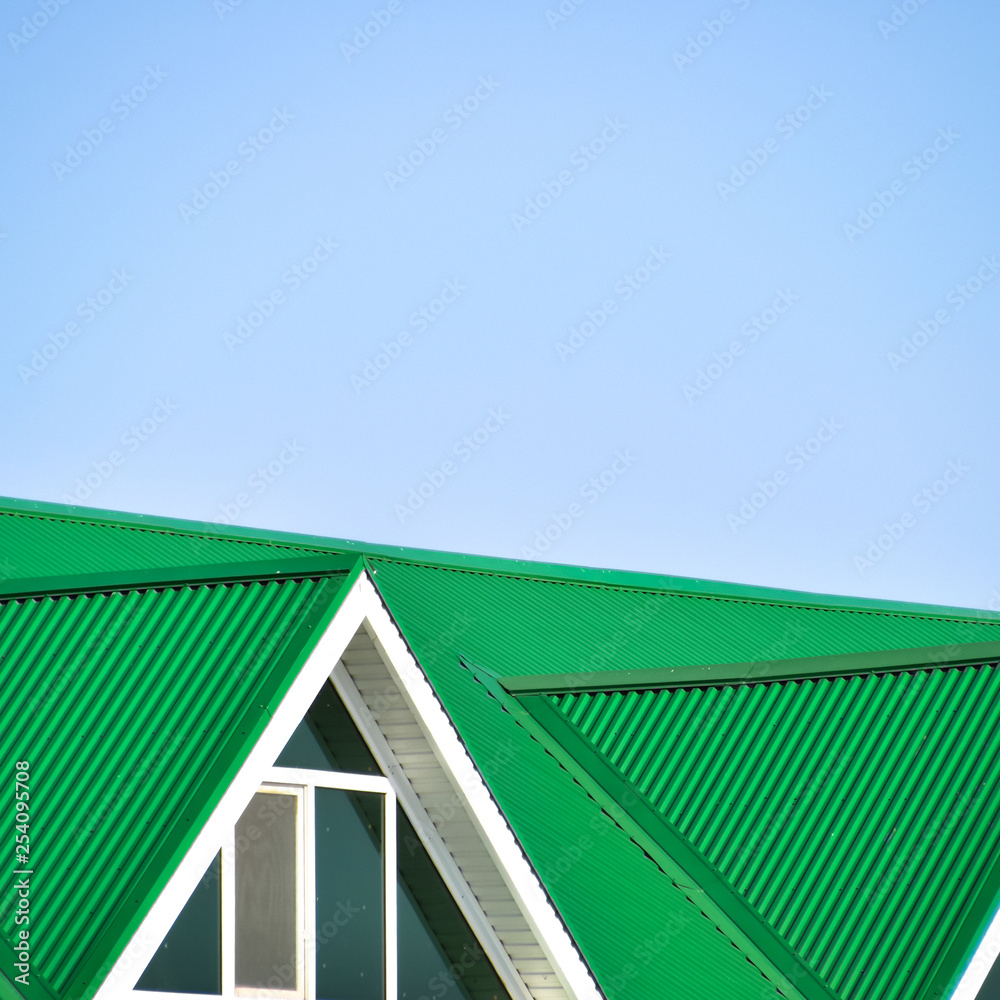 Fototapeta premium The house with plastic windows and a green roof of corrugated sheet