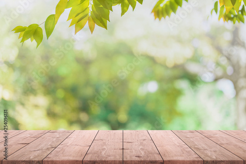 Empty wood table top and blurred view from green tree garden bokeh background - can used for display or montage your products.