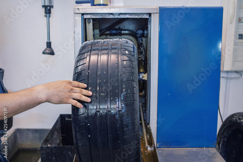car repair: wheel replacement closeup. mechanic screwing or unscrewing car wheel at car service garage