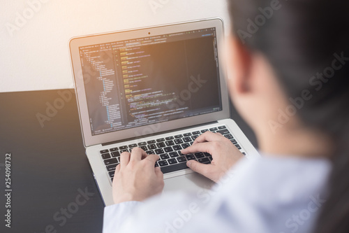 Young business woman programmer working at office. woman hands coding and programming on screen laptop, in programming concept