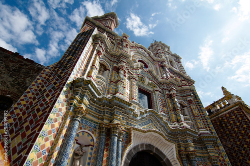 The Temple of San Francisco Acatepec is a religious monument typical of the Mexican baroque architecture, with Its facade of talavera tiles and red bricks, Cholula, Puebla, Mexico. photo
