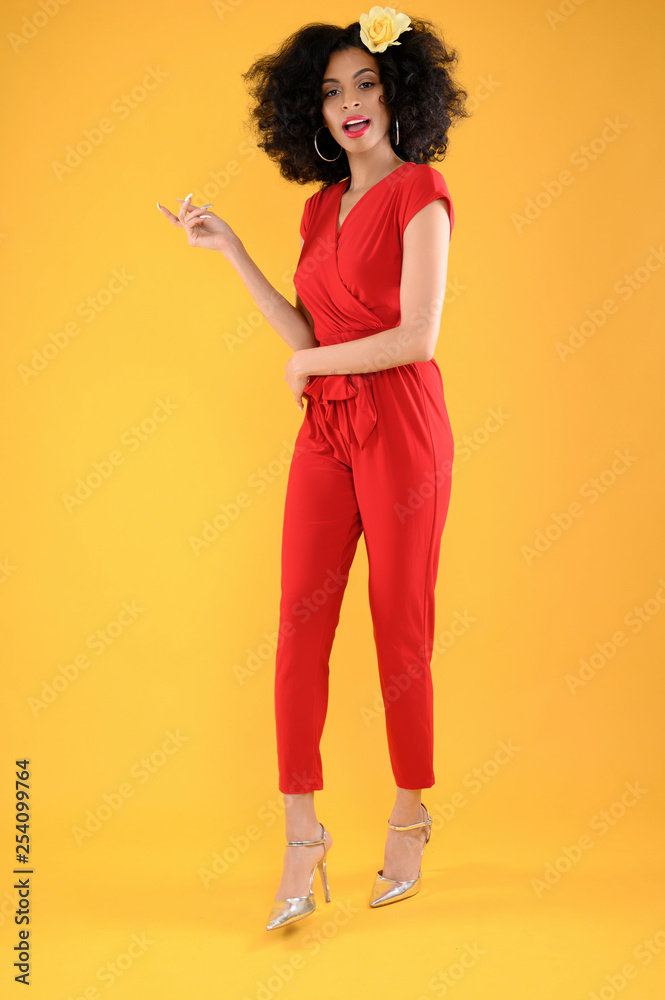 Young African American Woman in Red Jumpsuit on Yellow Background Young African American Woman in Red Jumpsuit on Yellow Background