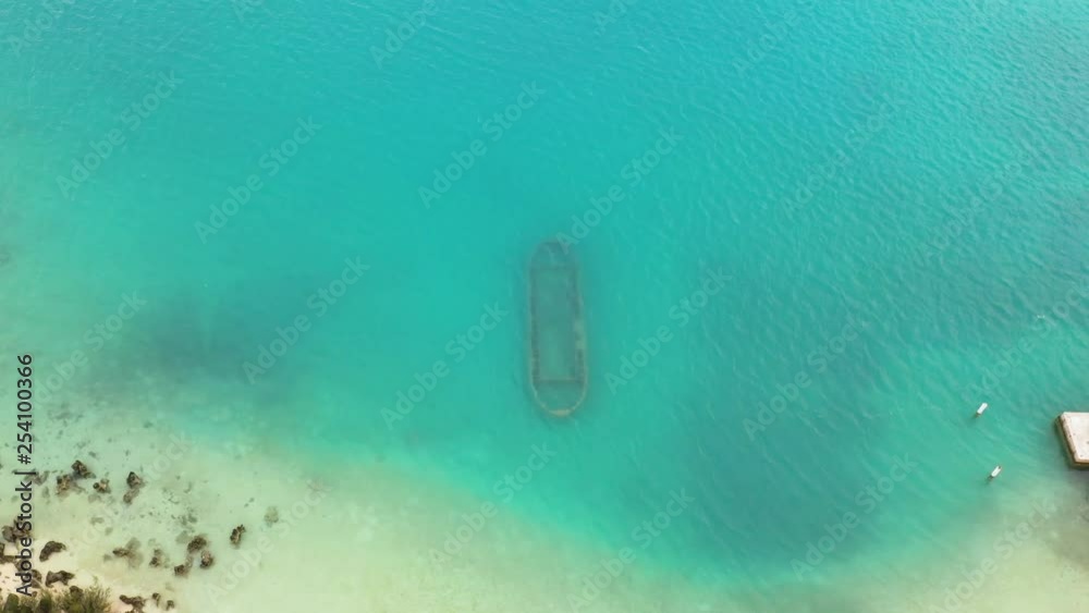 Aerial view of rusty shipwreck on seafloor in turquoise ocean. MOVING FORWARD.
