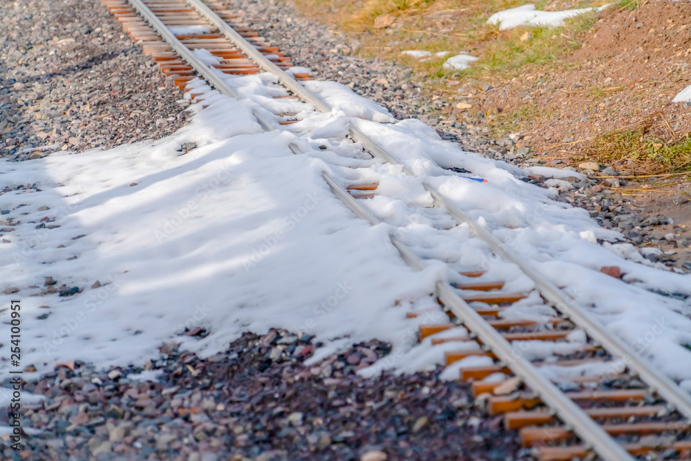 Sunlit snow covering a railway track in winter Sunlit snow covering a railway track in winter