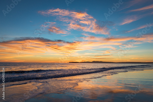 Sunset at Limantour Beach, Pt. Reyes California. Facing northwest with saturated colors and reflections in the water.