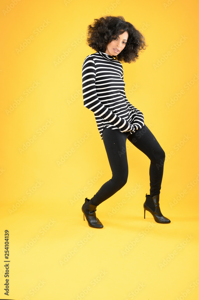 Young African American Woman Standing on a Yellow Background