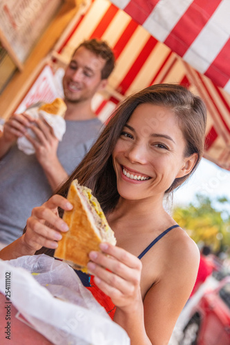 Happy Asian girl eating cuban sandwich at local cafe restaurant in Key West, Florida. Summer travel tourist lifestyle young Asian woman smiling eating lunch outside.