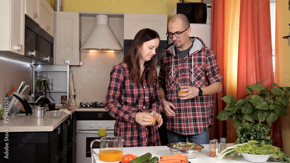 The guy and the girl talk in the kitchen and laugh while the food is prepared The guy and the girl talk in the kitchen and laugh while the food is prepared