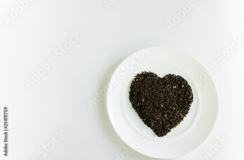 flower tea on a white plate in the shape of a heart a white background