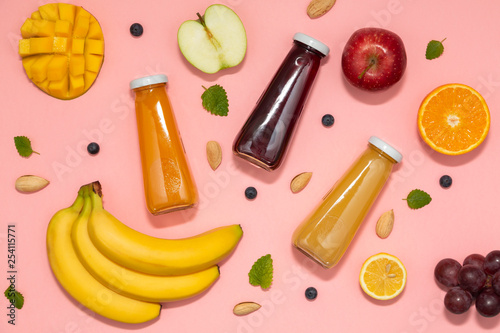 Colorful smoothies in bottles with fresh fruits on pink background. Flat lay. top view. Natural Organic Food Style. 