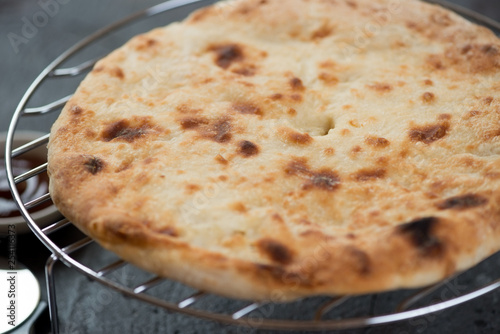 Close-up of ossetian pie on a metal cooling rack, selective focus, studio shot