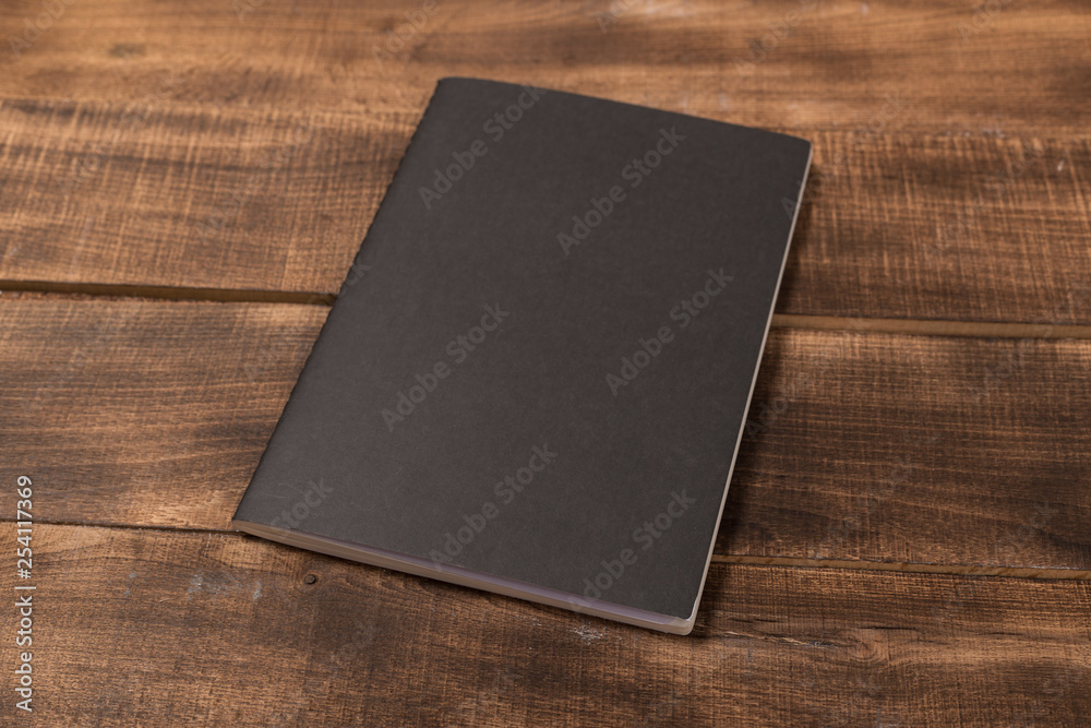 A blank notebook page and pen on wood office table. Top view with copy space. A blank notebook page and pen on wood office table. Top view with copy space.