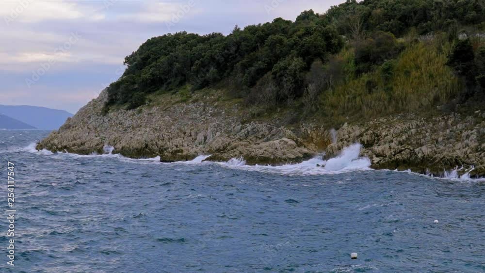 Close up of the waves crashing against the rocky coast of Brestova on a cloudy day. Croatia. Flat plane. Slow motion Close up of the waves crashing against the rocky coast of Brestova on a cloudy day. Croatia. Flat plane. Slow motion