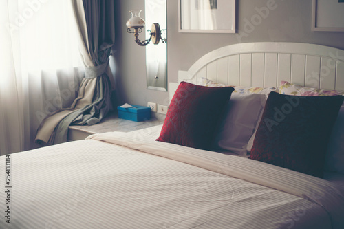 Red pillow on a white bed