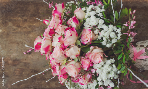 A bouquet of pink roses on wooden background. 