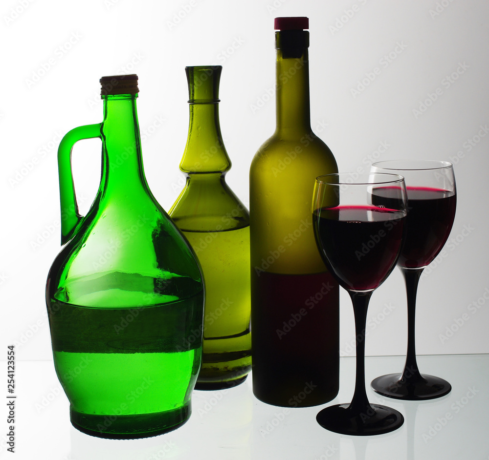 Two glasses of wine and bottles of wine and gin on the light. Two glasses of wine and bottles of wine and gin on the light.