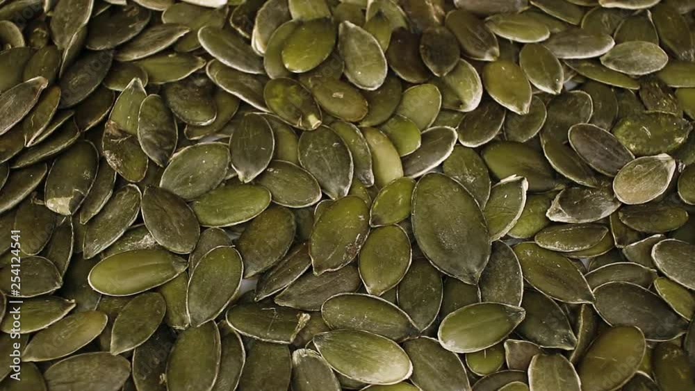 Green pumpkin seeds closeup texture video on rolling rotating looping plate Green pumpkin seeds closeup texture video on rolling rotating looping plate