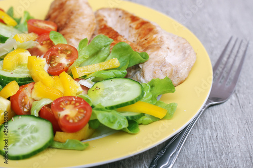 Grilled chicken breast with raw vegetables salad