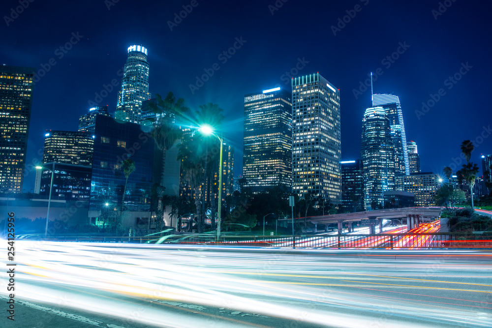 Traffic and light trails from the cars on freeway at night time rush hour  in big city with skyscrapers. Downtown Los Angeles in California Stock  Photo | Adobe Stock