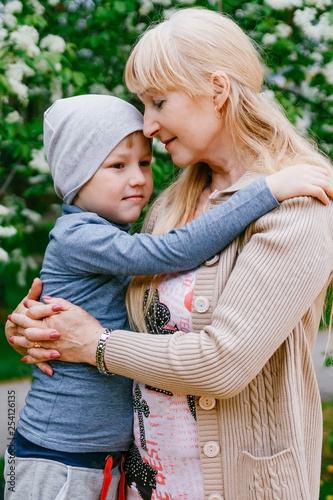 blond happy young grandma hugging child of five years