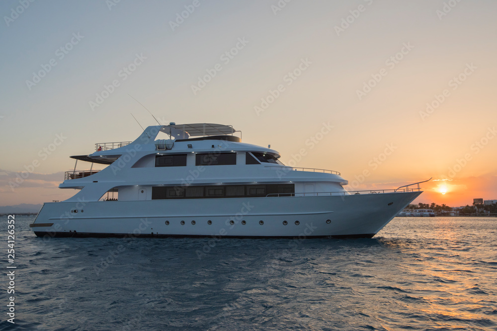 Luxury private motor yacht on tropcial sea at sunset
