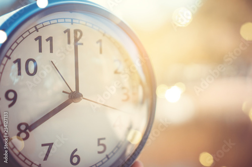 Selective focus of alarm clock with nature background.