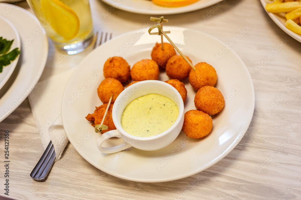 cheese balls on a plate and sauce