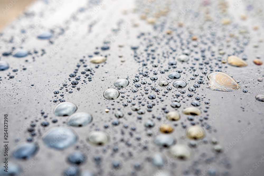 macro drops with colorful iridescence dark surface macro drops with colorful iridescence dark surface