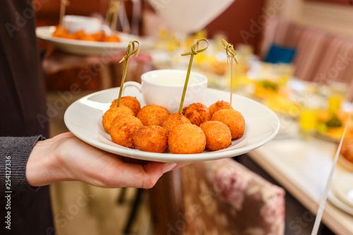 cheese balls in the hands of the waiter