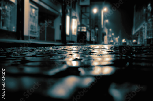 Foto Cobbled road on a city high street with buildings and lights at night with colou
