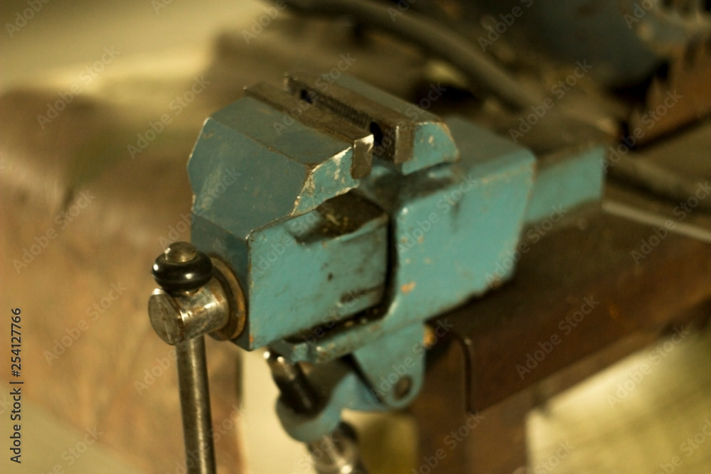 small blue working vise on the table in the garage small blue working vise on the table in the garage