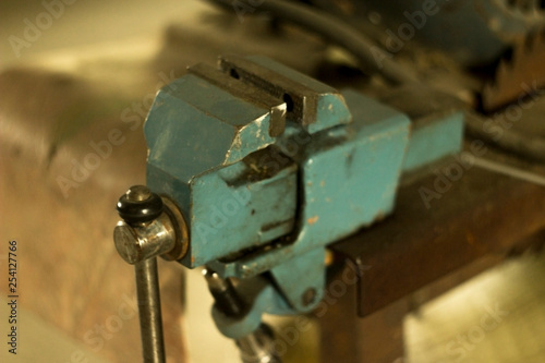 small blue working vise on the table in the garage