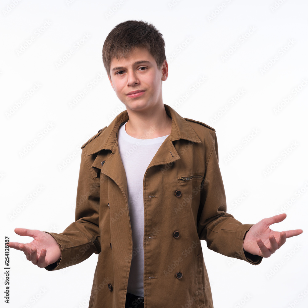 Portrait of surprised teen boy with divorced raised hands isolated on white background. A boy with a surprised face looks straight into the camera. Portrait of surprised teen boy with divorced raised hands isolated on white background. A boy with a surprised face looks straight into the camera.