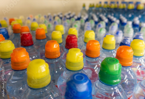 Lid plastic water bottle in the market. multi-colored plastic bottle caps 