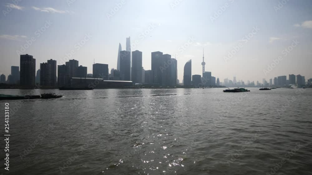 shanghai bund viewed from ferry ship, skyscrapers and landmarks with blue sky background, cargo ships sailing on Huangpu river, 4K video, slow motion. shanghai bund viewed from ferry ship, skyscrapers and landmarks with blue sky background, cargo ships sailing on Huangpu river, 4K video, slow motion.