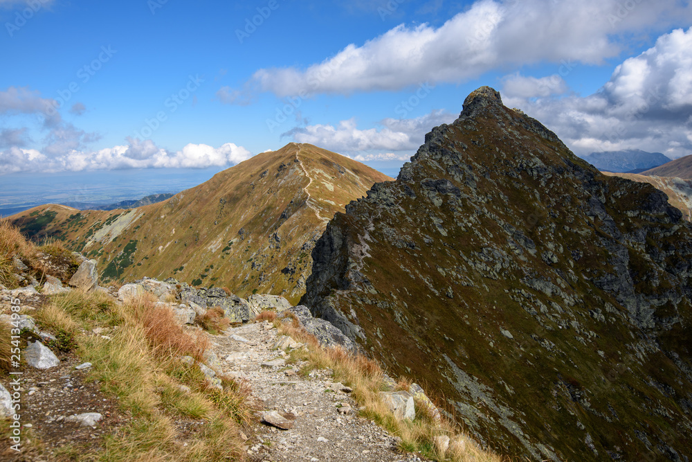 Tatra mountain peaks with tourist hiking trails in sunny summer day