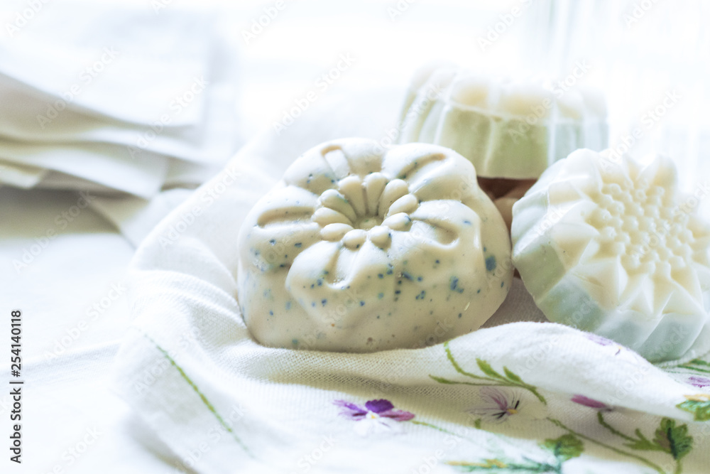 Handmade soaps on the white material, cleanliness and hygiene concept