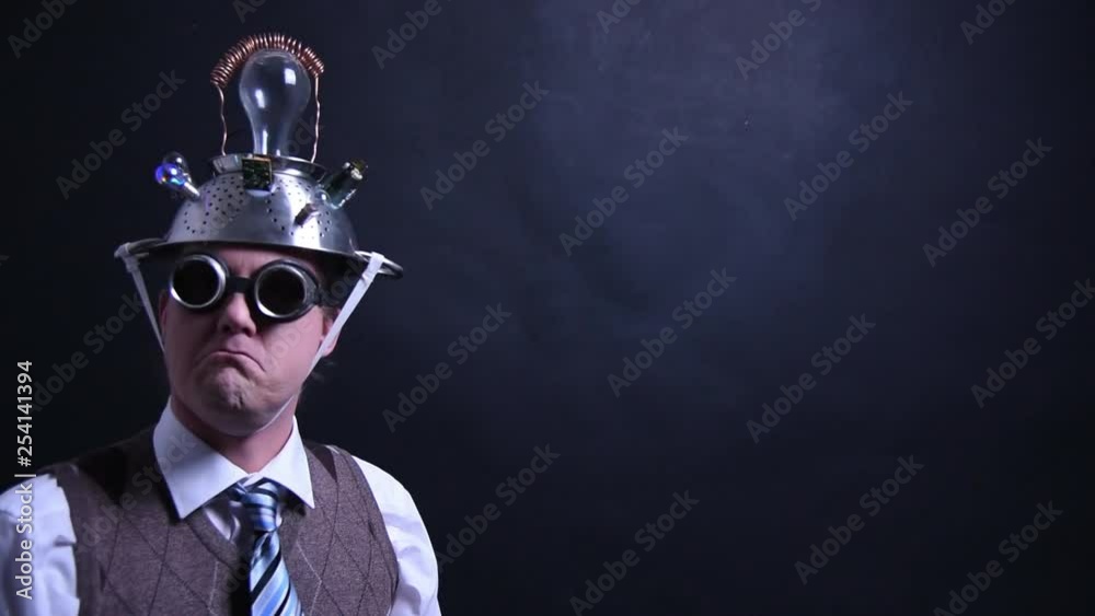 Nerd with aluminum hat looks into the camera