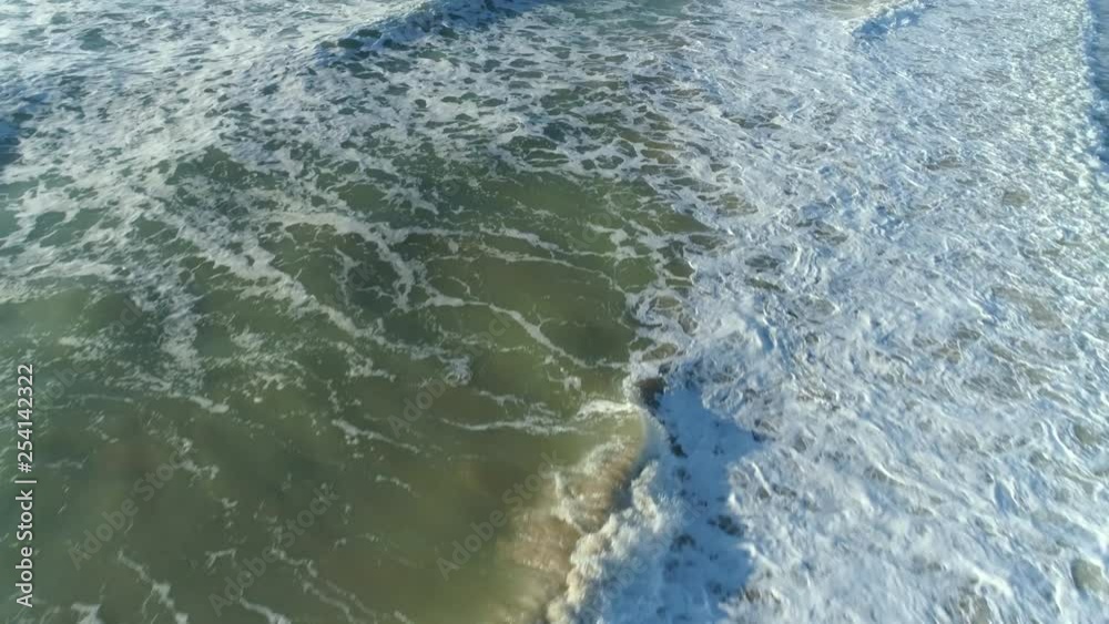 Aerial shot of ocean waves crashing an empty beach. Aerial view of waves. Aerial shot of ocean waves crashing an empty beach. Aerial view of waves.