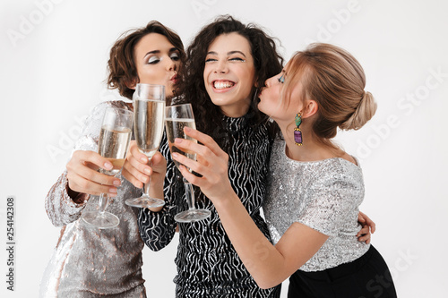 Young happy women friends posing isolated over white wall background. on a party.