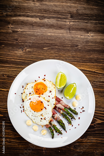 Fried egg with asparagus on white background