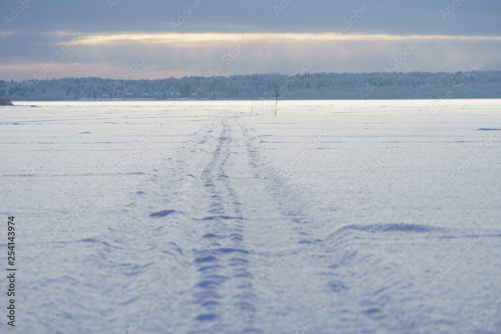 Landscape overlooking the winter trail on the lake, sunset