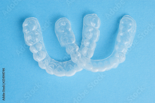 Plastic caps for teeth on a blue background, closeup