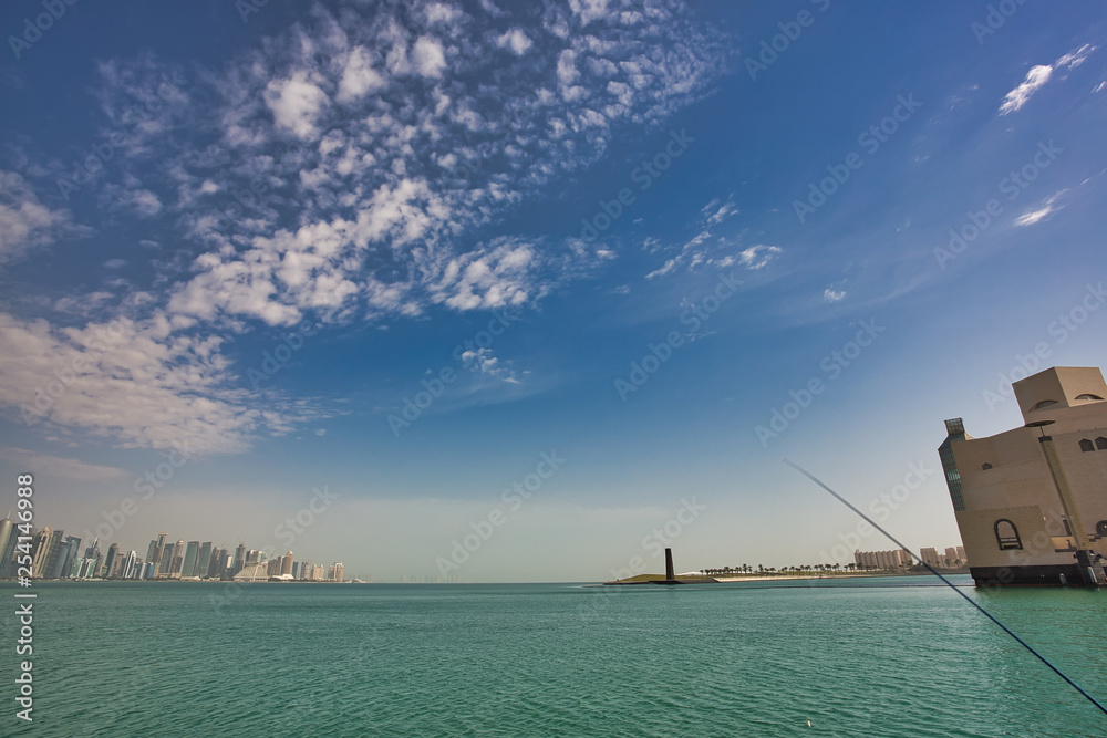 DOHA, QATAR - FEBRUARY 2, 2014: Wide view to the bay of Doha and Museum of Islamic Art from Dhow harbor capturing a fishing rod