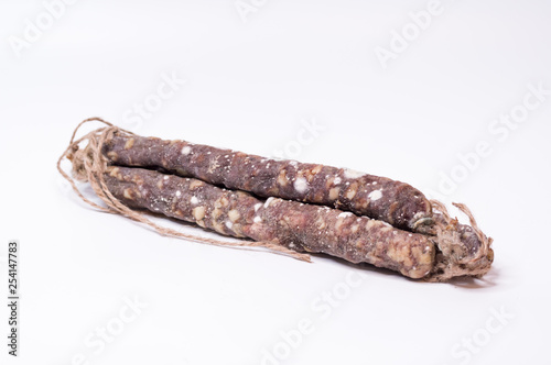 Three sticks of sausage with mold. Meat sausages in the center of the frame.