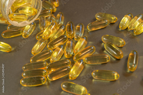 Gelatin capsules with the medicine are scattered across the table.
